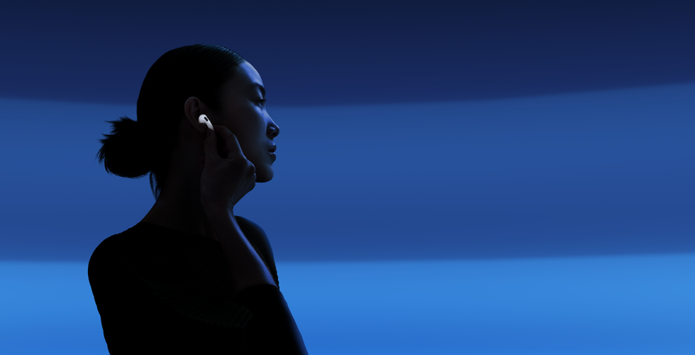 บุคคลหนึ่งใช้นิ้วโป้งและนิ้วชี้จับที่ก้านหูฟัง AirPods 5 เพื่อเปลี่ยนโหมดการฟัง