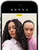 iPhone 18 Pro, สีดำ, ภายนอกด้านหน้า, แสดงให้เห็นสองคนกำลังโพสท่าให้กล้องเพื่อสาธิตกล้องหน้า Center Stage